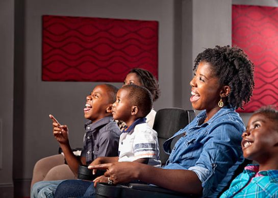 An African American family watching a movie laughing